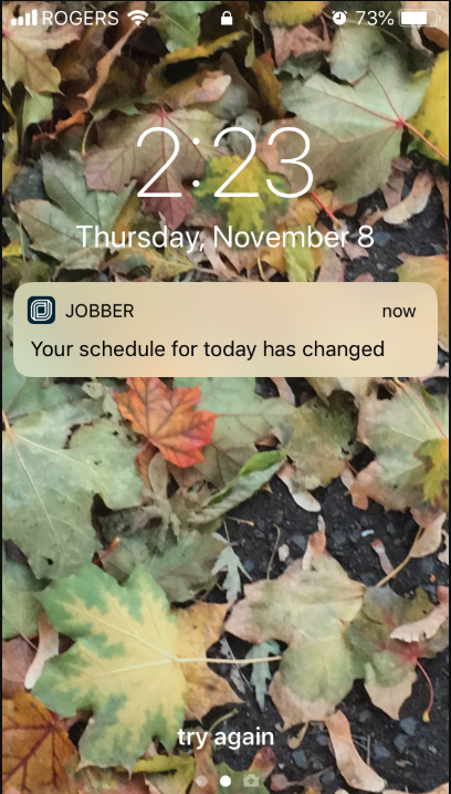 phone lock screen with a notification from Jobber that their schedule has changed